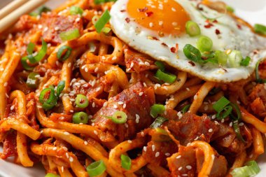 Kızarmış yumurta ve pastırmalı Kimchi Udon Noodle. Kore yemeği.