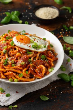 Kızarmış yumurta ve pastırmalı Kimchi Udon Noodle. Kore yemeği.