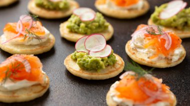 Yumuşak peynirli mini blini krep, soğuk füme somon ve guacamole..