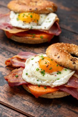 Pastırmalı sandviç, ahşap masada yumurta ve peynir.