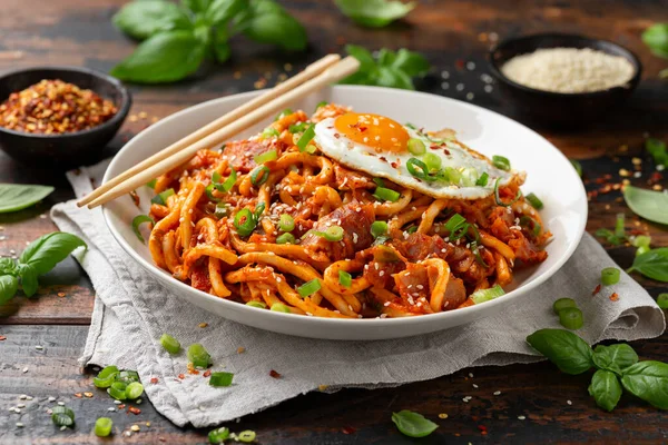 Kızarmış yumurta ve pastırmalı Kimchi Udon Noodle. Kore yemeği.