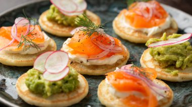 Yumuşak peynirli mini blini krep, soğuk füme somon ve guacamole..