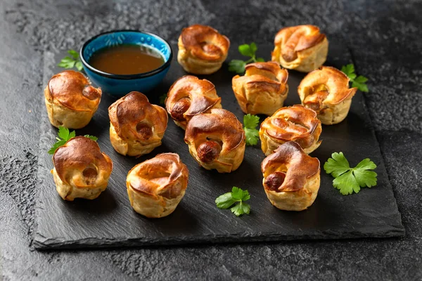 Mini Toad in the hole, Baked sausages in Yorkshire pudding with gravy.