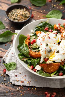 Kavrulmuş tereyağlı kabak salatası haşlanmış yumurta, ıspanak, fındık ve nar tohumlarıyla servis edilir..