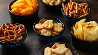 Tuzlu abur cuburlar, patates cipsleri, krakerler, fıstıklı mısır gevrekleri