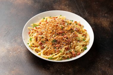 Kızarmış ekmek kırıntıları, pastırma ve parmesan peynirli spagetti.
