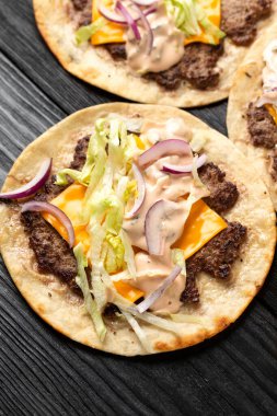 Ev yapımı Taco soslu, peynirli, marullu ve soğanlı hamburger ezmesi..