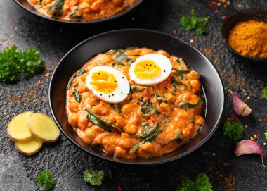 Nohut, ıspanak, domates ve yumurtalı köri sağlıklı yiyecekler.