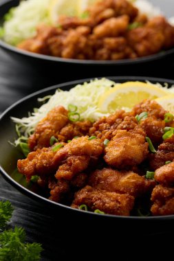 Kızarmış Japon Kızarmış Tavuk Karaevi. Siyah kâse içinde pirinç ve lahana..