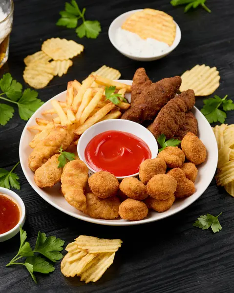 Tavuk nugget, güney şeritleri, tavuk parmak, patates kızartması, cips, çeşitli soslar ve bira..