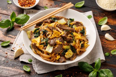 Thai Pad See Ew with beef, eggs, vegetables and rice noodles clipart