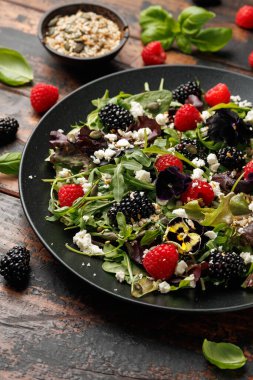 Yaz meyveli salata, yenilebilir çiçekler, peynir ve tohumlar..