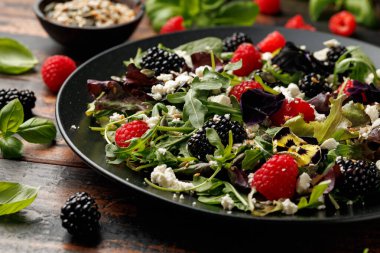 Yaz meyveli salata, yenilebilir çiçekler, peynir ve tohumlar..