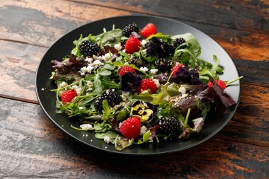 Yaz meyveli salata, yenilebilir çiçekler, peynir ve tohumlar..