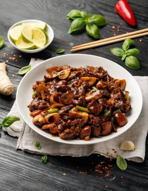 Biftek mantarı kızartması zencefil ve sarımsak ile karıştırın beyaz tabakta.