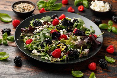 Yaz meyveli salata, yenilebilir çiçekler, peynir ve tohumlar..