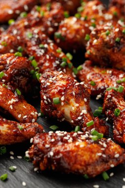 Spicy korean chicken wings with sesame seeds and chives. clipart