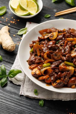 Biftek mantarı kızartması zencefil ve sarımsak ile karıştırın beyaz tabakta.