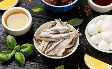 Salamura edilmiş ançüez, zeytin ve mini mozzarella peyniri çeşitleri. Sağlıklı atıştırmalıklar.