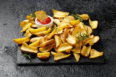 Taş tahtada ketçaplı kızarmış patates kızartması..