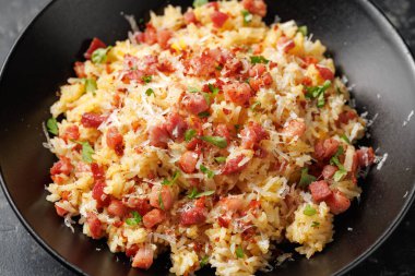 Pancetta 'lı Carbonara pilavı, pecorino romano peyniri, siyah kasede yumurtalar..