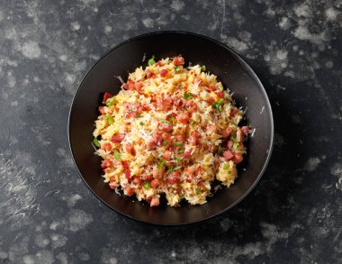 Pancetta 'lı Carbonara pilavı, pecorino romano peyniri, siyah kasede yumurtalar..