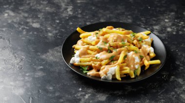 Lezzetli geleneksel Kanada yemeği poutine sosu ve peynirli patates kızartması. Döndürme videosu.