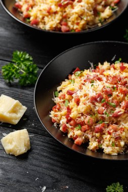 Pancetta 'lı Carbonara pilavı, pecorino romano peyniri, siyah kasede yumurtalar..