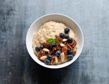 Yabanmersinli yulaf lapası, badem ve pekan cevizli sağlıklı kahvaltı.