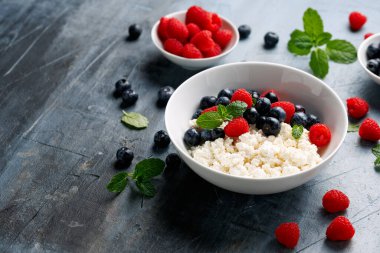 Bir kase süzme peynir, yaban mersinli peynir ve ahududu. Yüksek proteinli sağlıklı kahvaltı veya öğle yemeği.