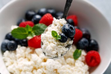 Bir kase süzme peynir, yaban mersinli peynir ve ahududu. Yüksek proteinli sağlıklı kahvaltı veya öğle yemeği.