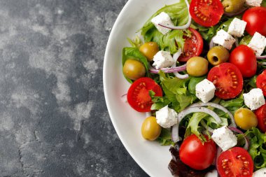 Peynirli, domatesli, zeytinli, soğanlı ve fesleğenli taze Akdeniz salatası, sağlıklı yiyecekler..