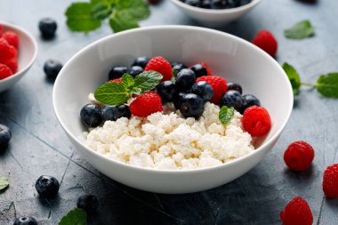 Bir kase süzme peynir, yaban mersinli peynir ve ahududu. Yüksek proteinli sağlıklı kahvaltı veya öğle yemeği.