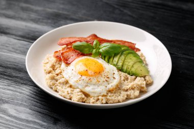 Yağda yumurta, domuz pastırması ve avokado ile birlikte lezzetli yulaf ezmesi kahvaltısı. Sağlıklı yemek..