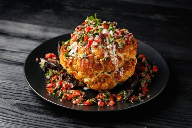 Taze salsa soslu ve Yunan yoğurdu soslu tam kavrulmuş Karnabahar kafası. Sağlıklı yemek..