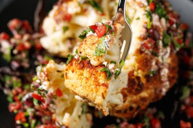 Taze salsa soslu ve Yunan yoğurdu soslu tam kavrulmuş Karnabahar kafası. Sağlıklı yemek..