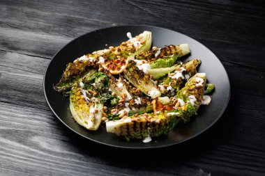 Grilled little gem lettuce with aioli sauce, roasted pine nuts and chilli flakes. Healthy Low carb side salad.