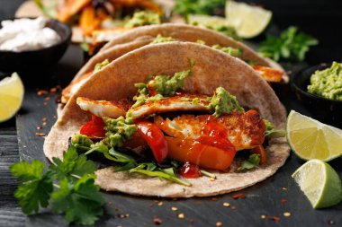 Kavrulmuş soğan ve dolmalık biber, avokado guacamole ve biber turşusu ile kızarmış halloumi fajitas..