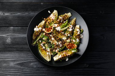 Grilled little gem lettuce with aioli sauce, roasted pine nuts and chilli flakes. Healthy Low carb side salad.