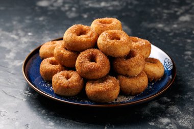 Mini tarçın şekerli çörekler mavi tabakta.