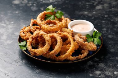 Soslu ev yapımı kızarmış soğan halkaları.