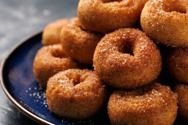 Mini tarçın şekerli çörekler mavi tabakta.