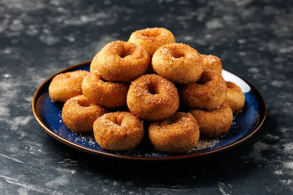 Mini tarçın şekerli çörekler mavi tabakta.