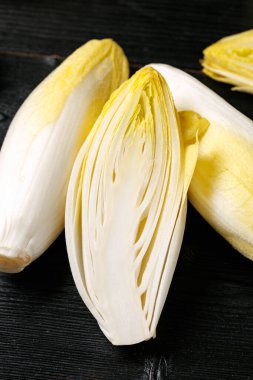 Çiğ hindiba ya da hindiba salatası kökleri ahşap arka planda.