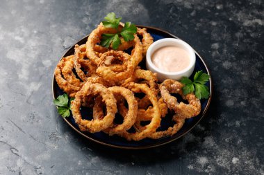 Soslu ev yapımı kızarmış soğan halkaları.