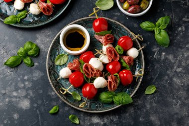 Salam, mozarella ve domatesli mini şiş aperatifler. Sağlıklı antipasto şişi.