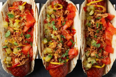 Sosisli, turşulu, domatesli ve kızarmış soğanlı Taco Hot Dog..