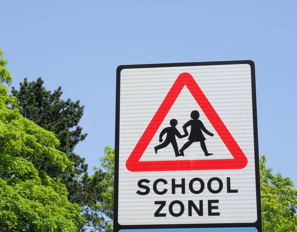 赤い三角形の子供のグラフィックを示す英国の道路標識は 地域が学校のゾーンであることをドライバーに警告します ロイヤリティフリーのストック写真