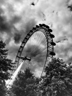 Ünlü milenyum çarkı ya da Londra Gözü, siyah beyaz dramatik bulutlu gökyüzünde