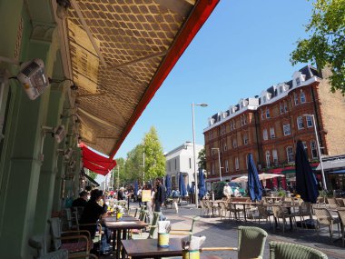 İnsanlar yazın Londra 'nın Kensington bölgesinde dışarıda yemek yiyorlar.